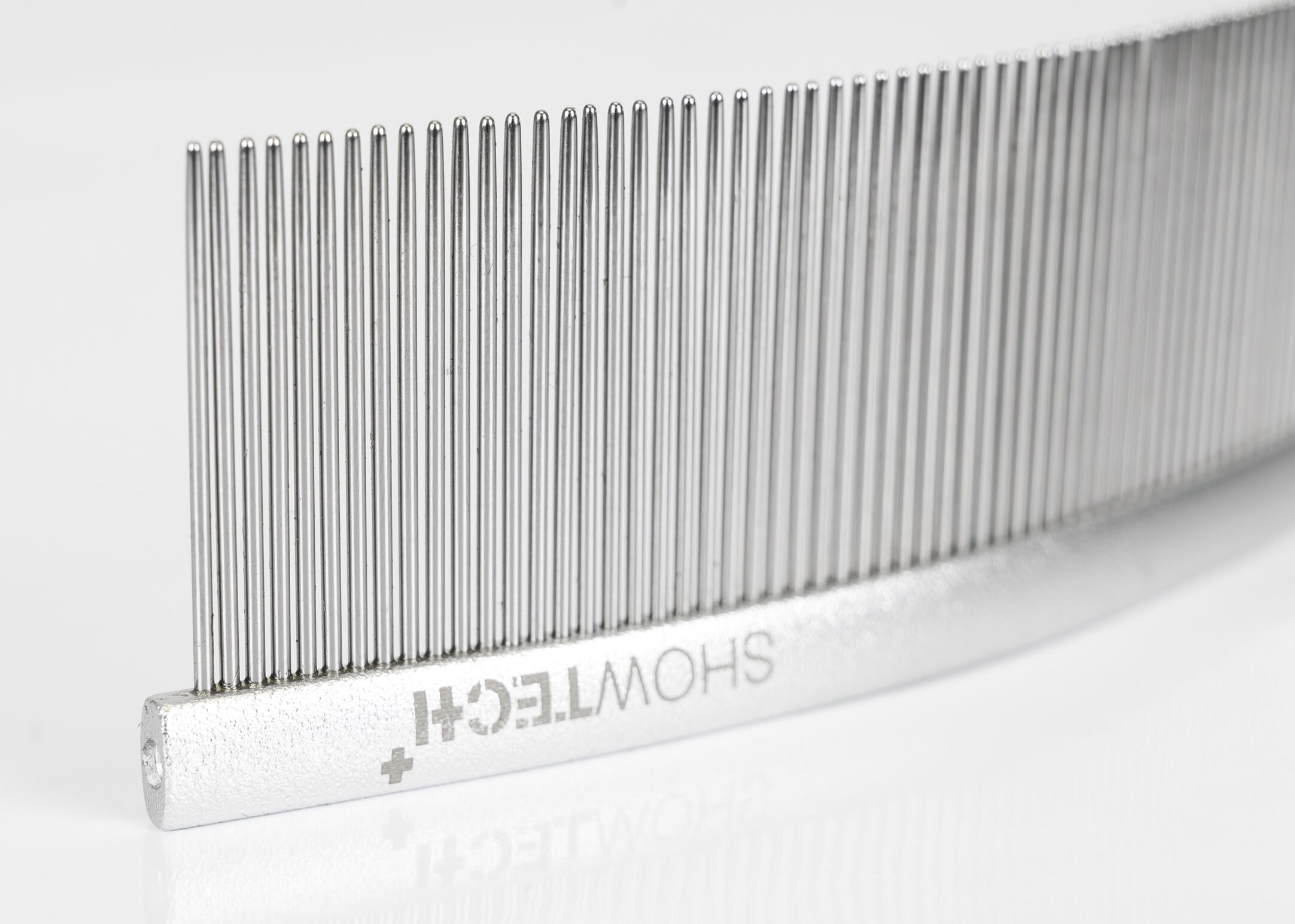 Nærbilde av Show Tech Featherlight Swirl Combi Comb med lange avrundede tenner og lett aluminiumskonstruksjon for skånsom pelspleie.